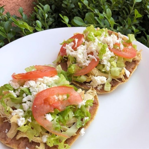 Tostada de frijoles con pollo y queso fresco