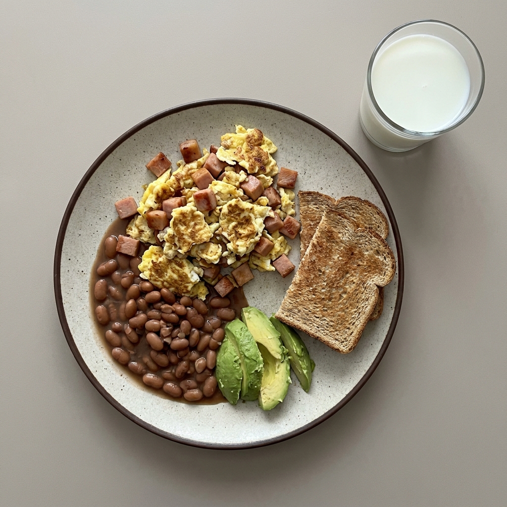 Huevos con jamon de pavo, frijoles de olla y aguacate, con pan integral y vaso de leche