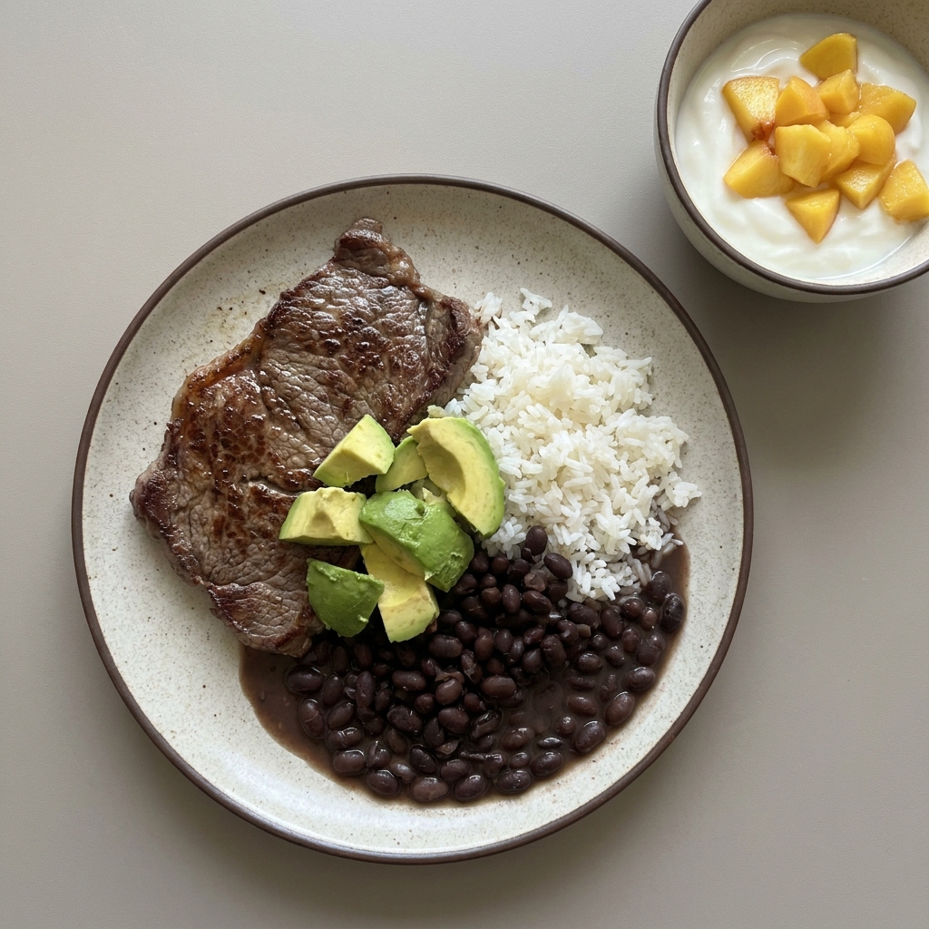 Bistec a la plancha con arroz, frijoles y aguacate, con bowl de yogurt y durazno