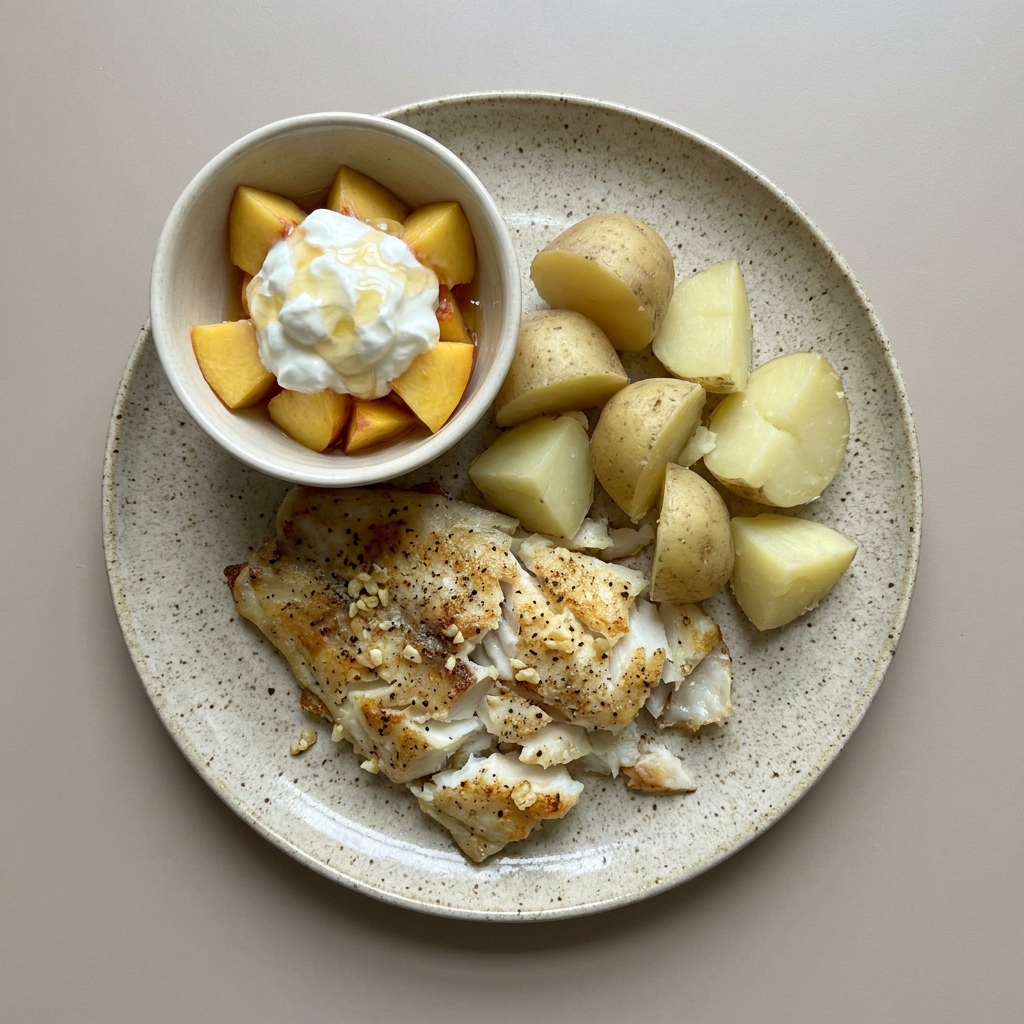 Pescado blanco al horno con papa y bowl de durazno con yogurt griego y miel