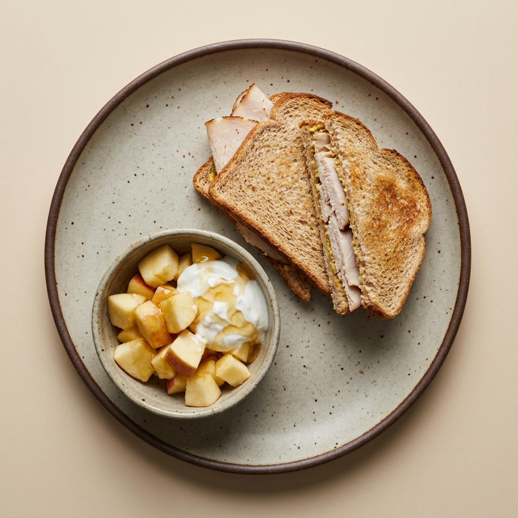 Sándwich de pechuga de pavo con bowl de manzana, yogurt griego y miel