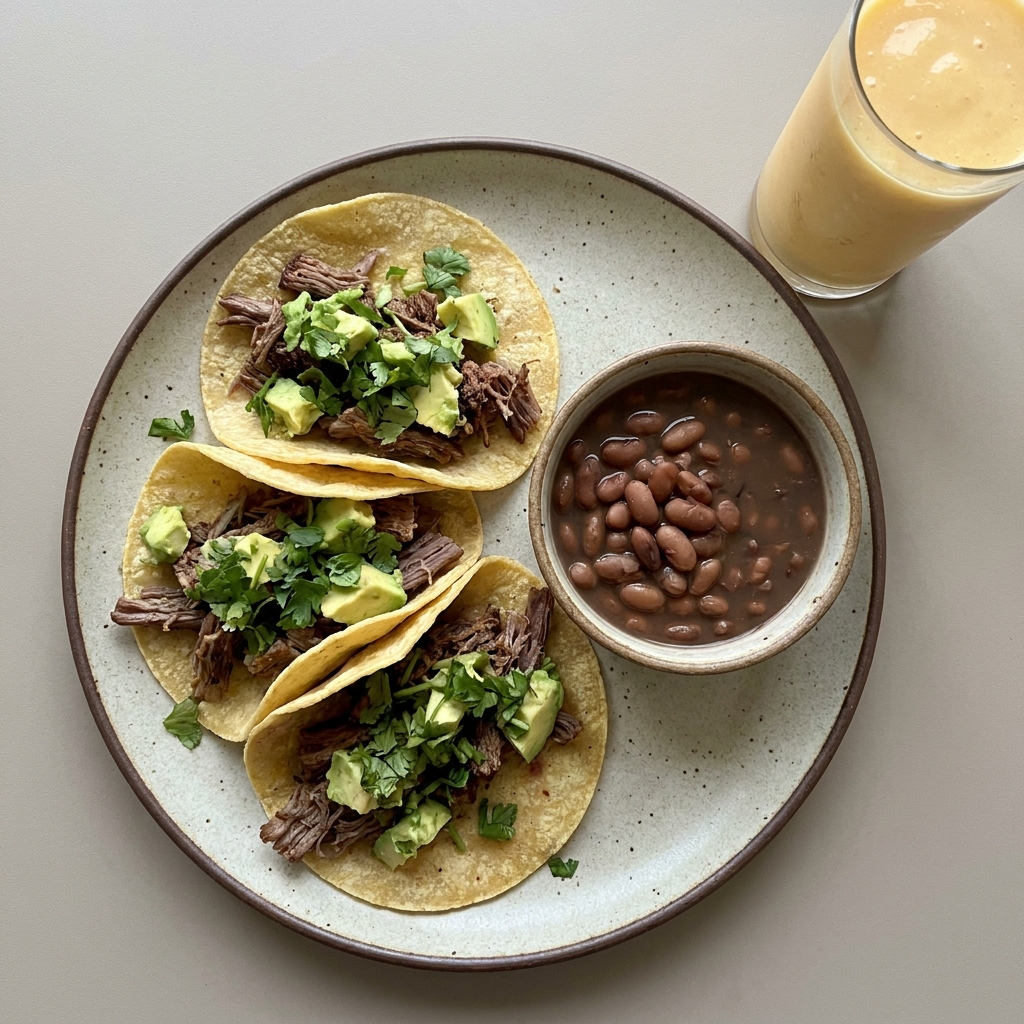Tacos de res deshebrada con aguacate y frijoles de la olla, con licuado de mango