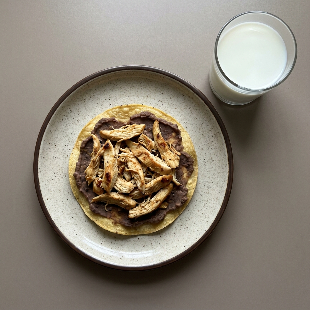 Tostada horneada de frijol con pechuga de pollo y vaso de leche