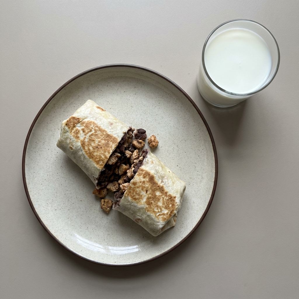 Burrito de frijol con pollo molido y acompaña con un vaso de leche