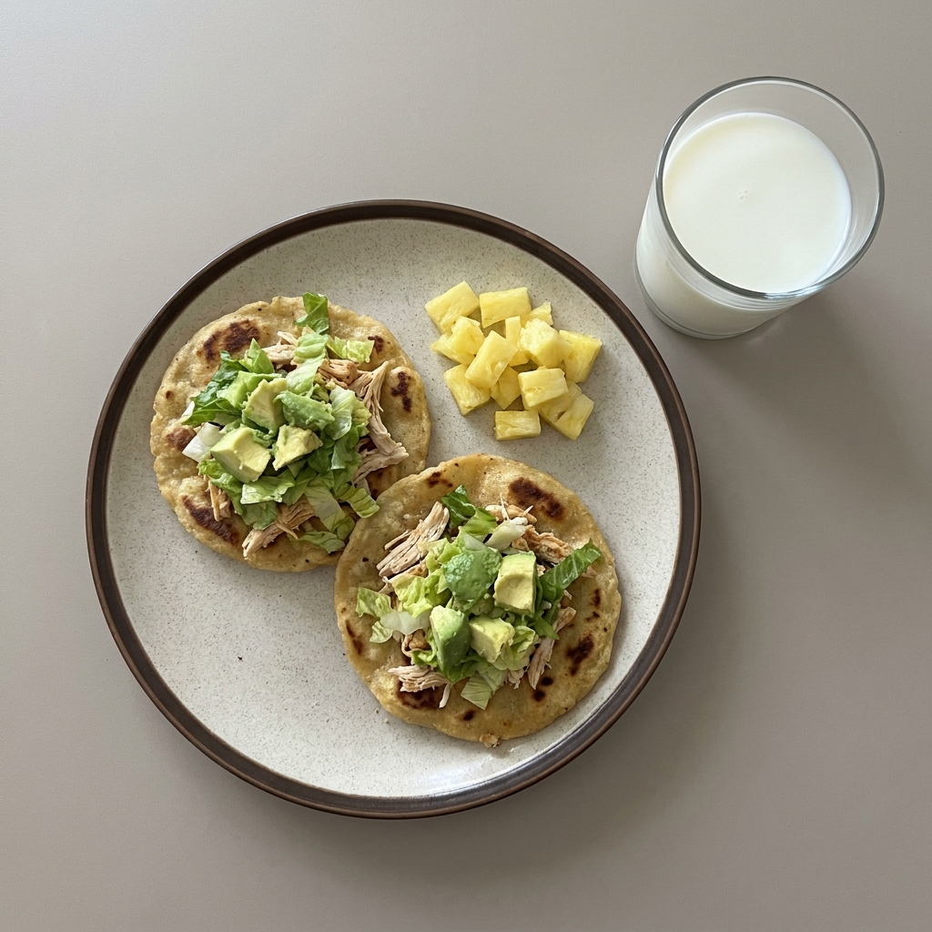 Sopes de pollo con lechuga y aguacate, con piña y vaso de leche