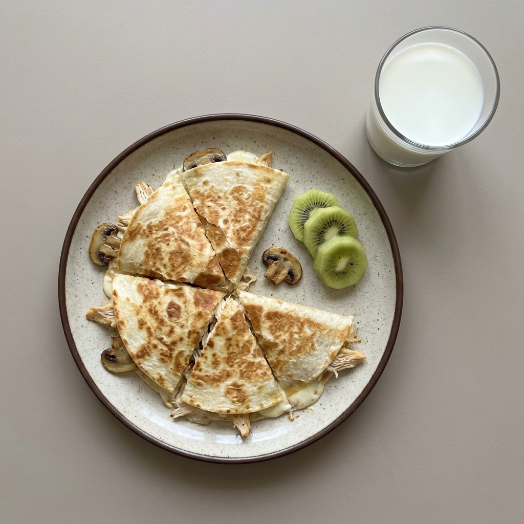 Sincronizada de pechuga de pollo y queso panela con champiñones, acompañada de fruta y leche