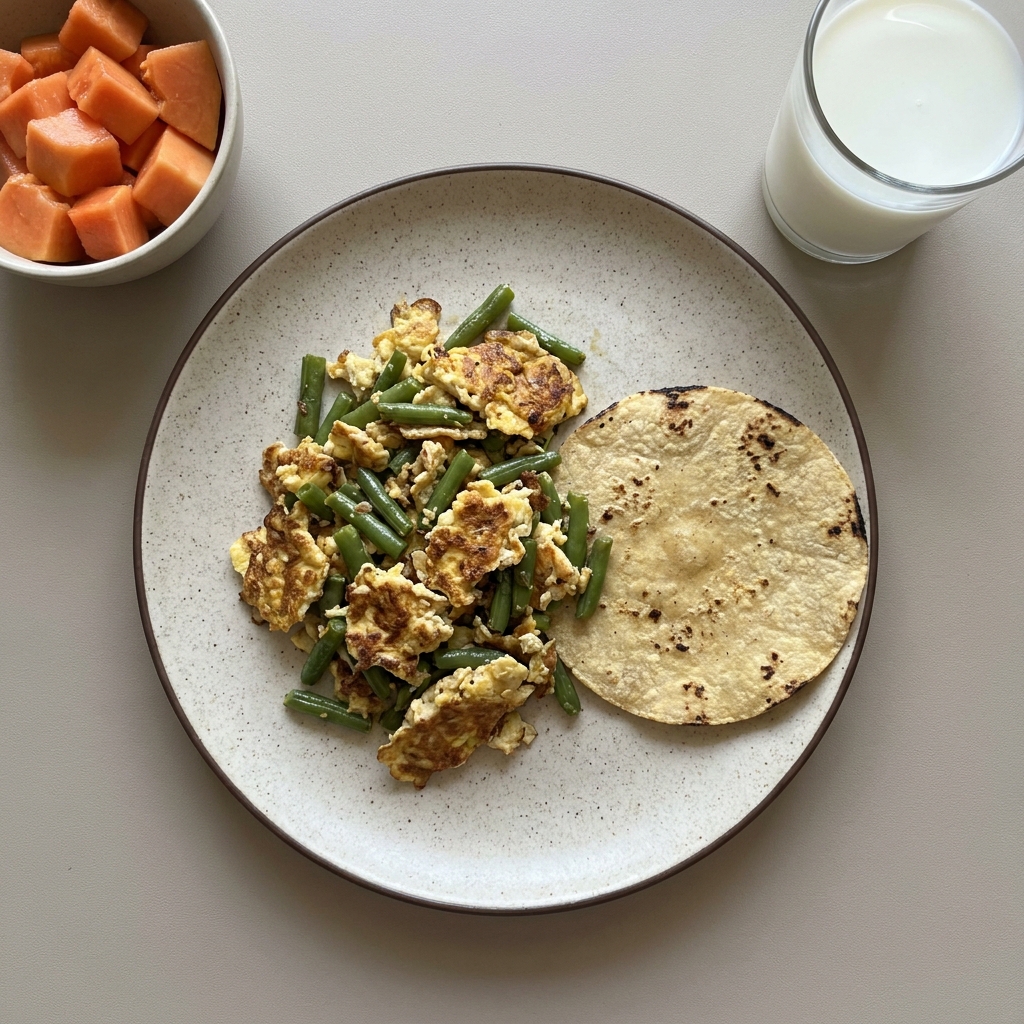 Huevo con ejote, tortilla de maíz, bowl de papaya y vaso de leche