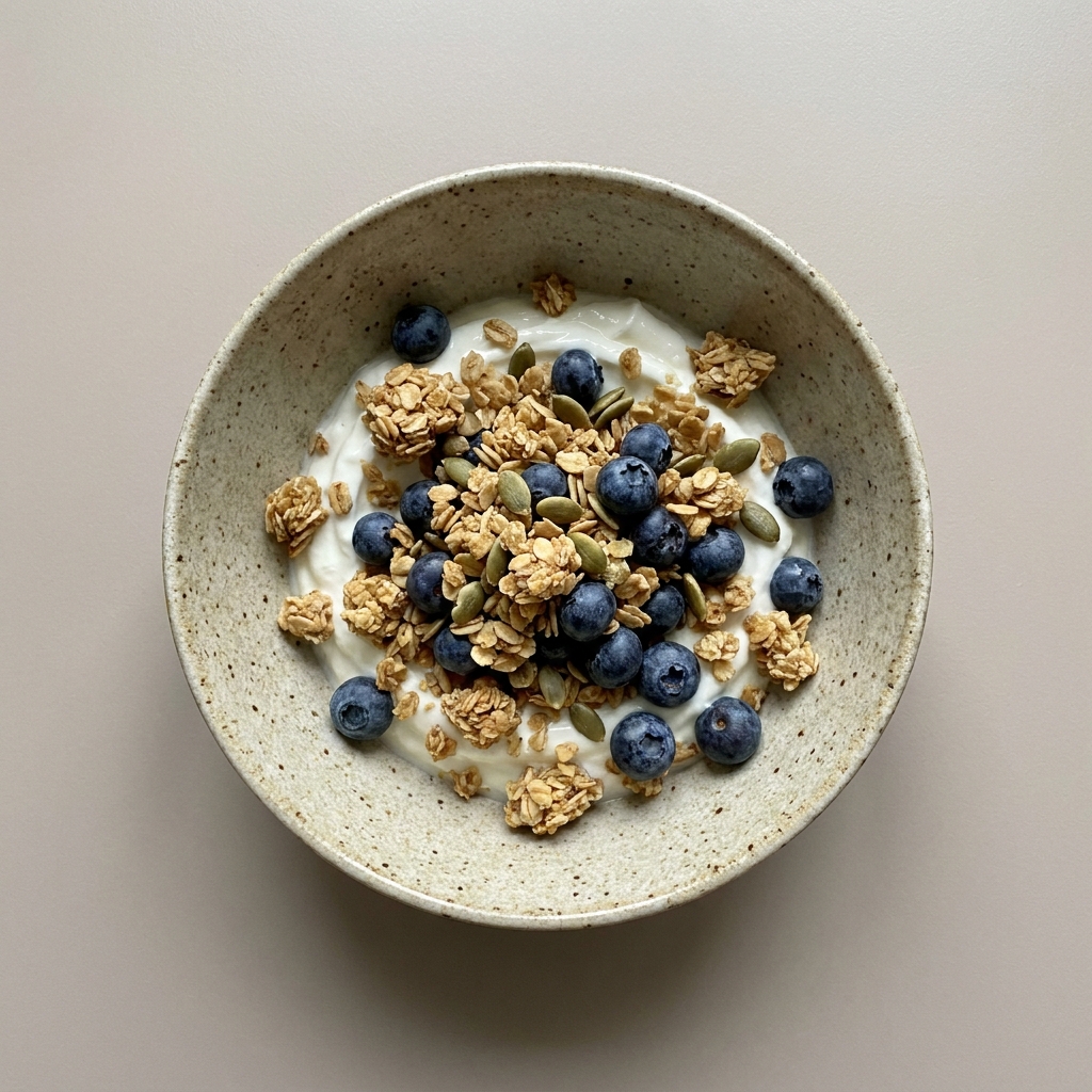 bowl de Yogurt griego con granola, arándanos y  pepitas de calabaza