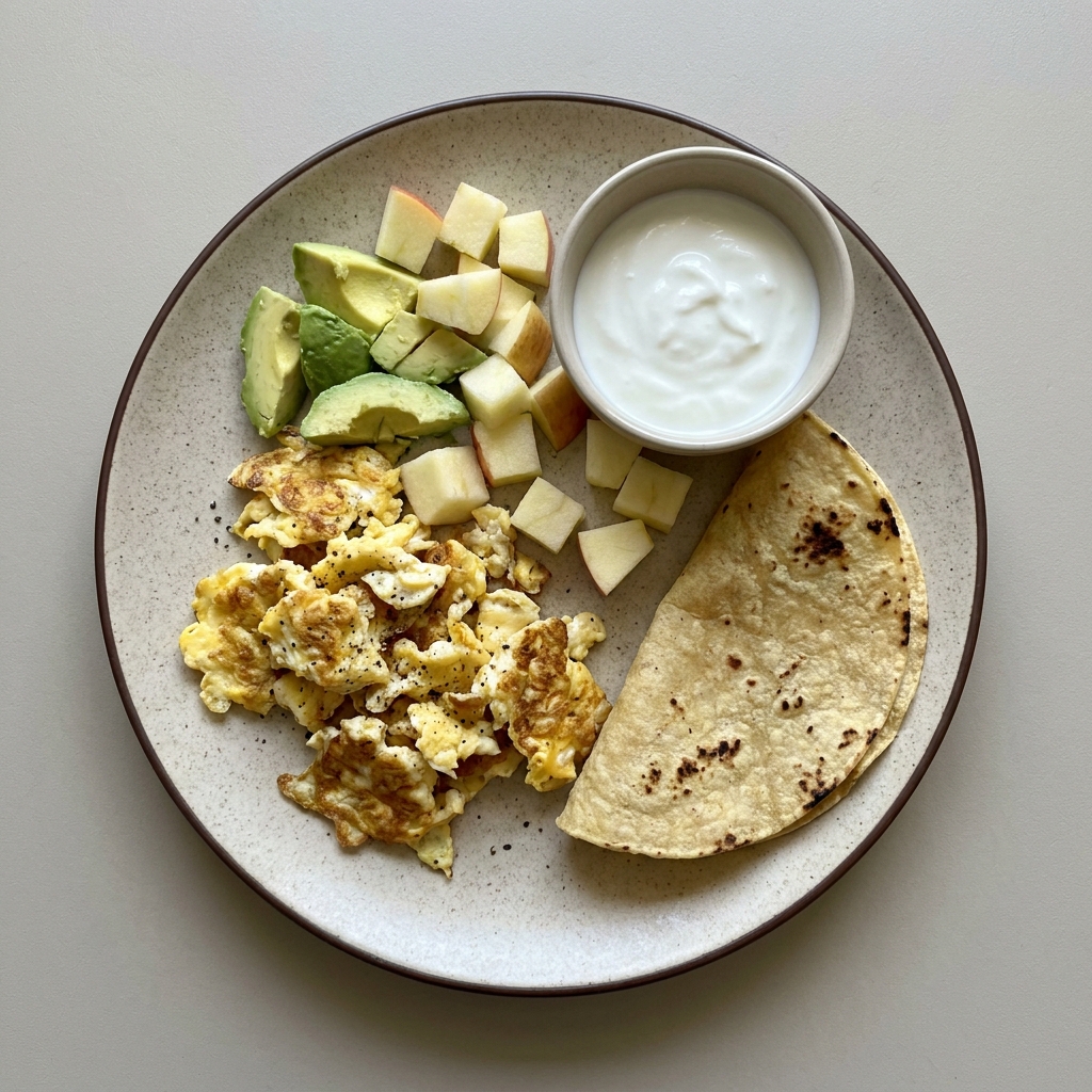 Huevo revuelto con aguacate y tortilla de maíz, con manzana picada y jocoque
