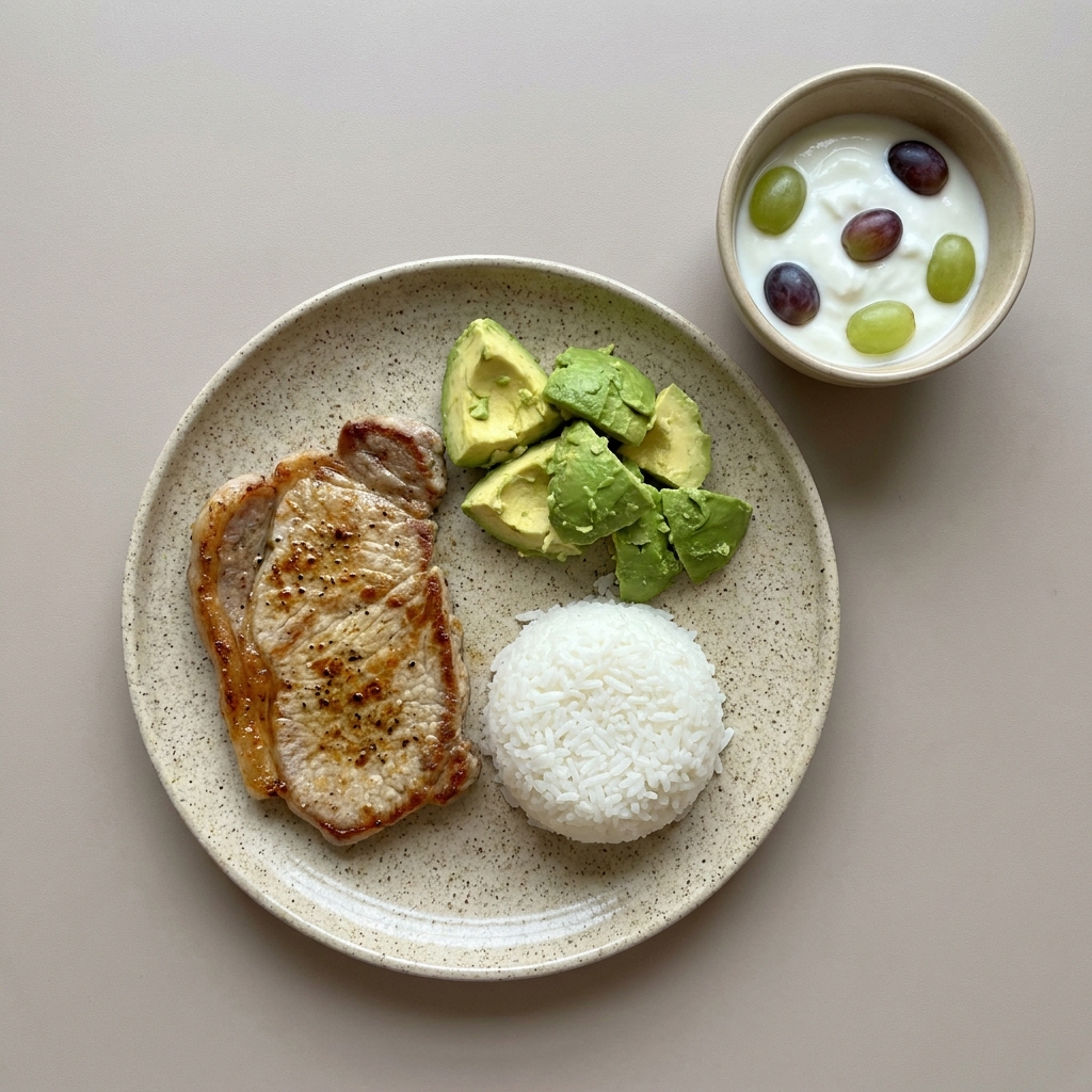 Bistec a la plancha con arroz y aguacate, acompañada de yogurt con uva