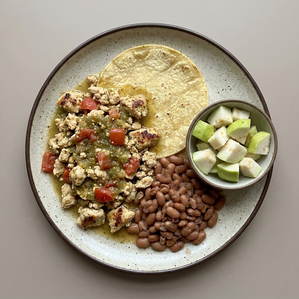 Pechuga de pollo molida en salsa verde con jitomate, tortilla de maíz, acompañada de guayaba picada