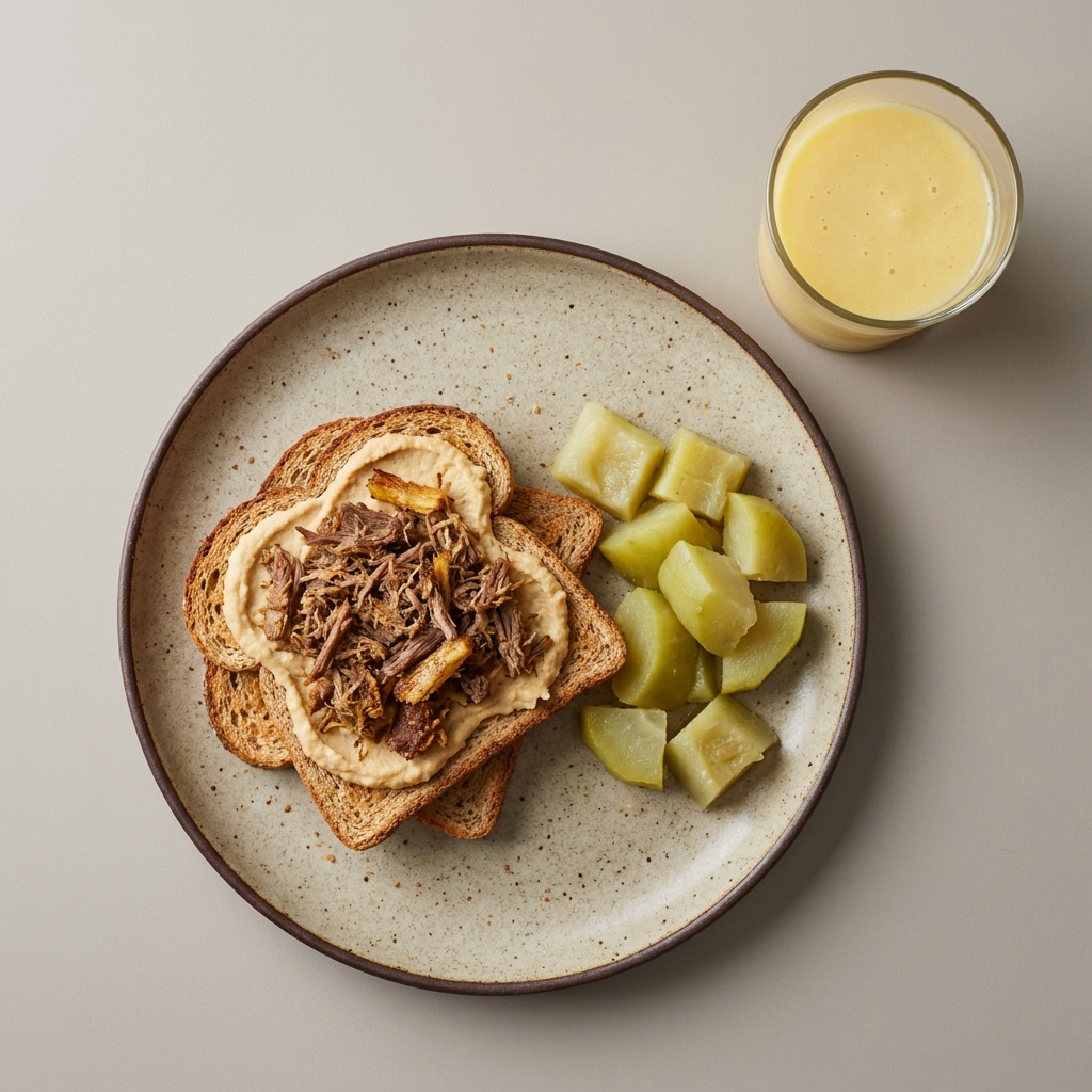 Pan integral con machaca de res, verdura y hummus, acompaña con licuado de fruta