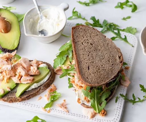 Sándwich de pan blanco con salmón ahumado y arúgula
